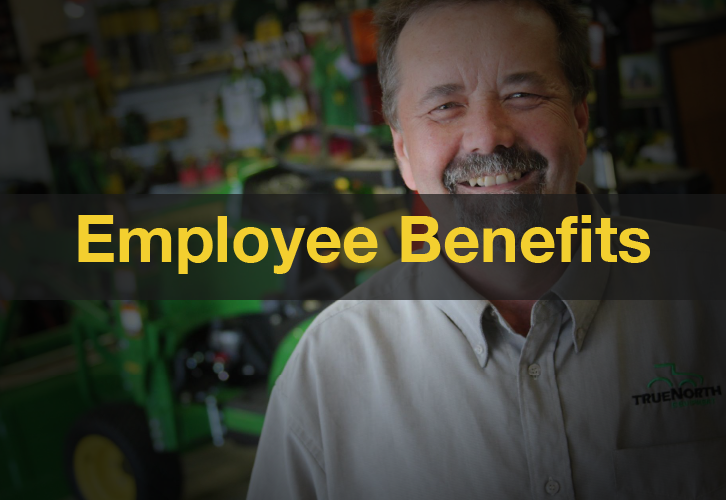 Employee smiling in front of John Deere equipment