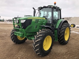 An used John Deere Tractor on a field.