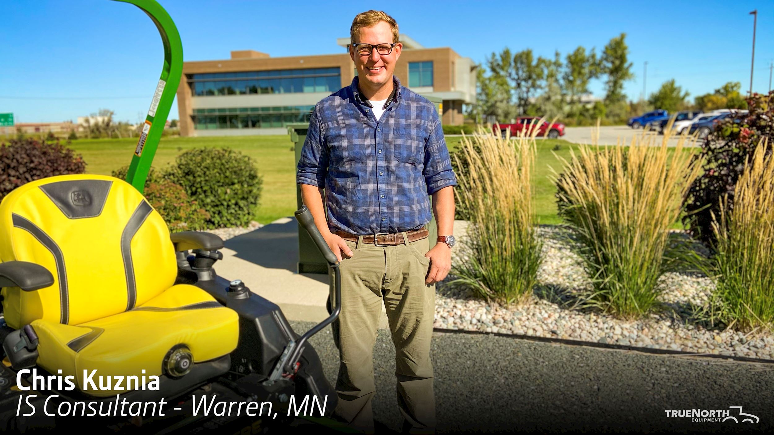 Chris Kuznia standing by John Deere Lawn Tractor