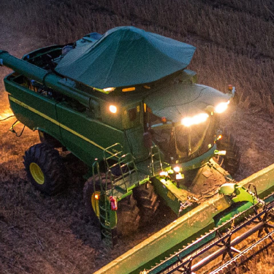 John Deere Combine in wheat field at night